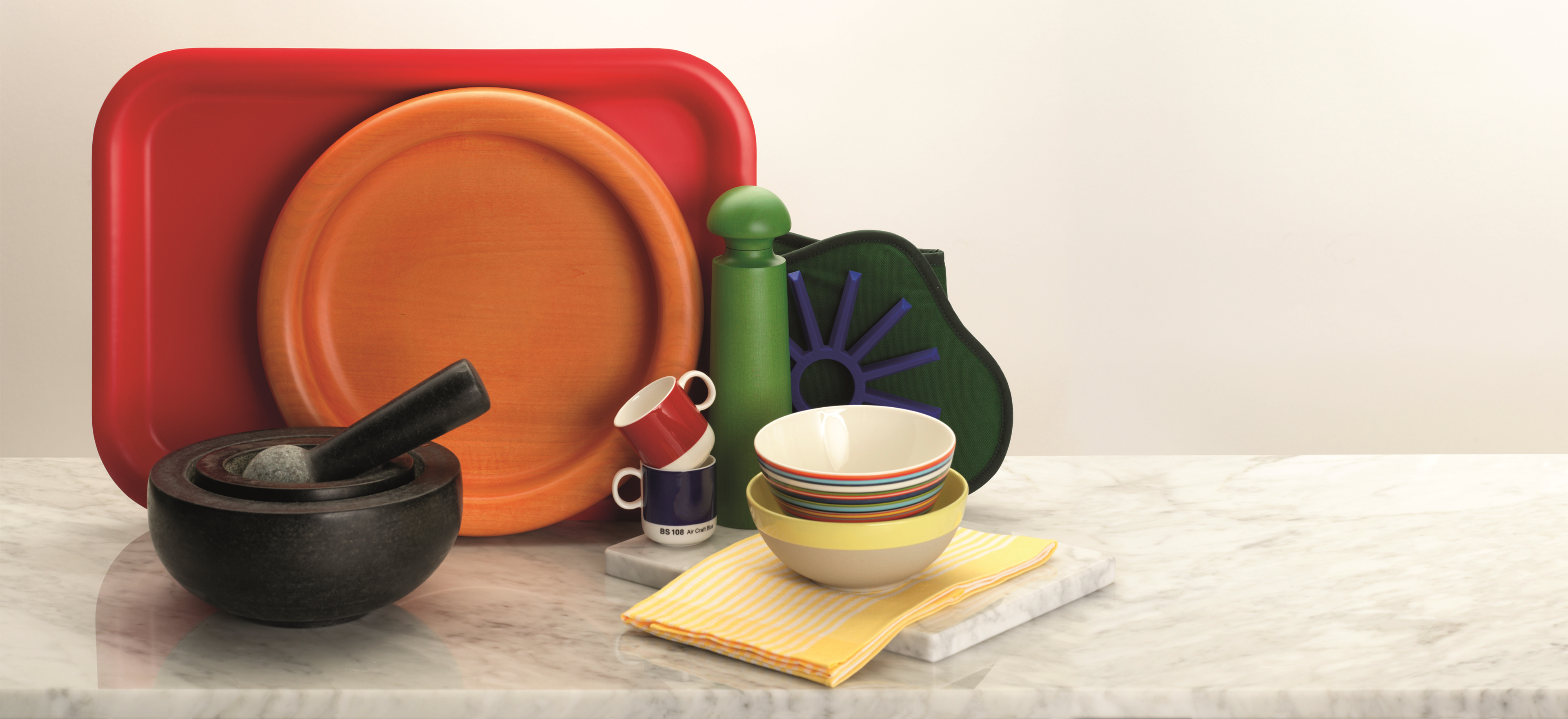 Featuring the David Mellor red plywood tray, Manzoni Pietro orange low fruit bowl 34cm, David Mellor large salt/pepper mill green, David Mellor hunter green double oven glove,  David Mellor silicone trivet blue, David Mellor medium black granite pestle & mortars, David Mellor BS538 Post Office Red espresso cup 9cl, David Mellor BS108 Aircraft Blue espresso cup 9cl, Origo Orange medium bowl 14cm, David Mellor yellow stoneware cereal/soup bowl 15.5cm, Swiss yellow stripe kitchen towel