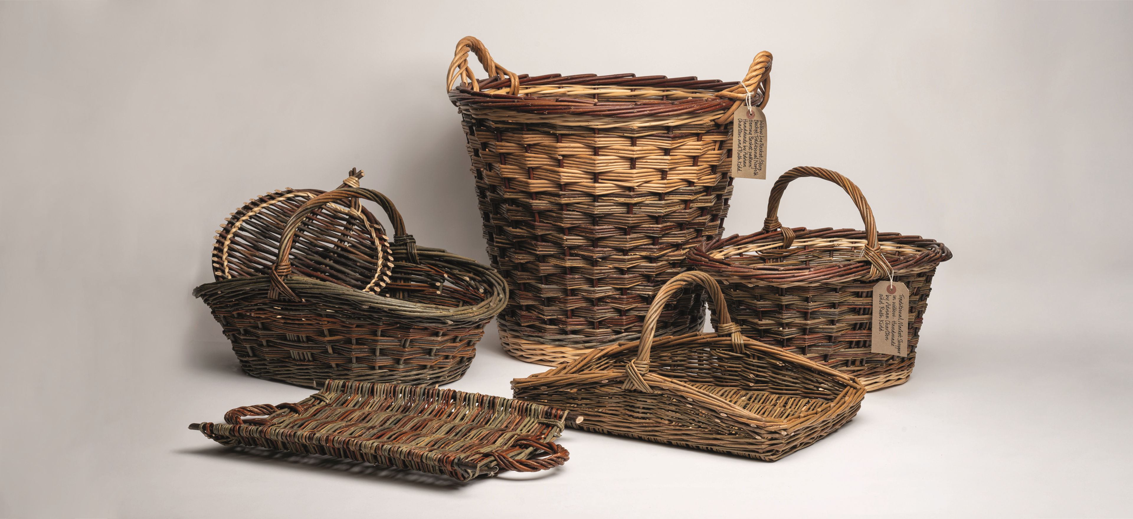 The Norfolk Basket Company baskets on a grey background.