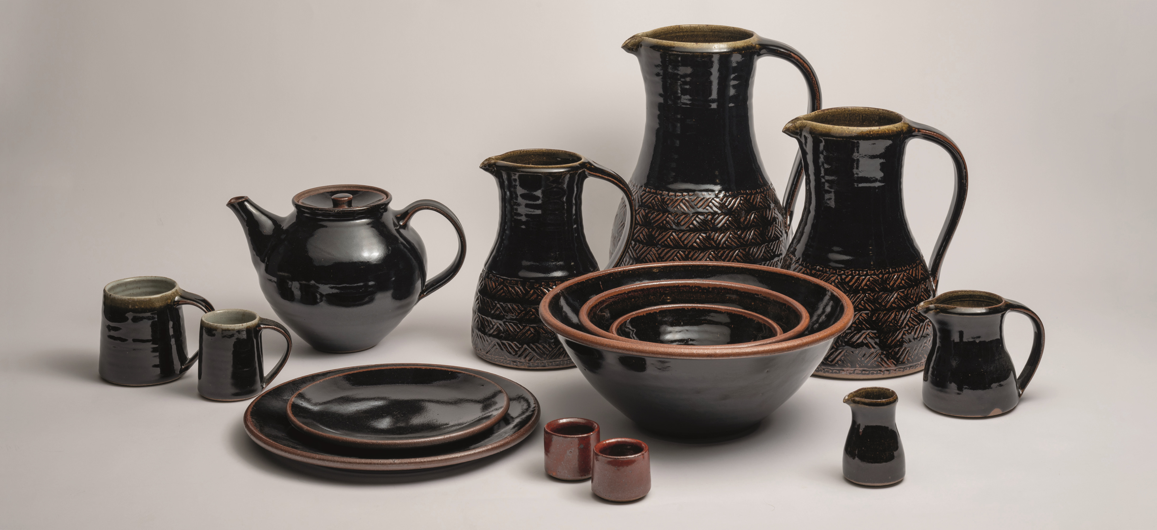 Tenmoku by Leach pottery from St. Ives on a grey background.