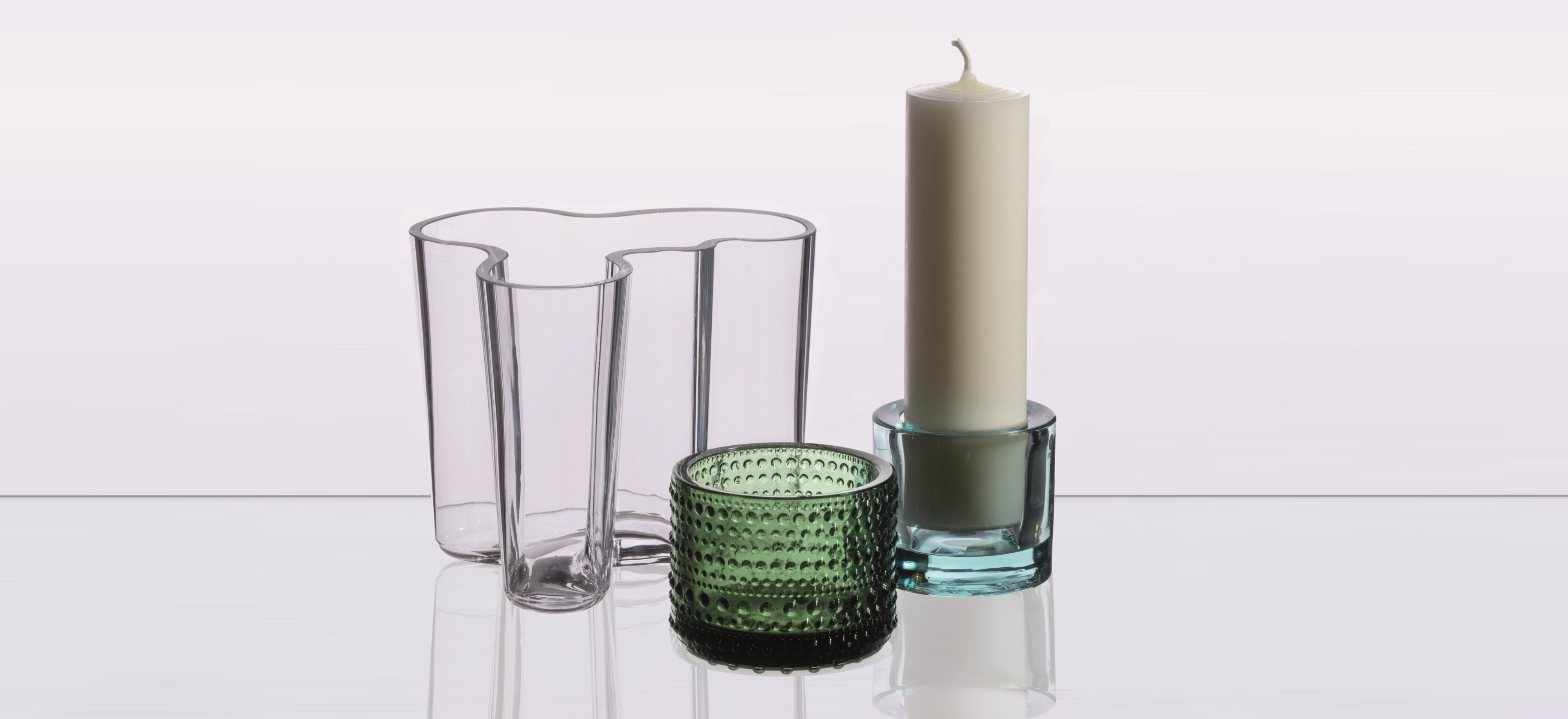 Various decorative glass items arranged on a grey background.