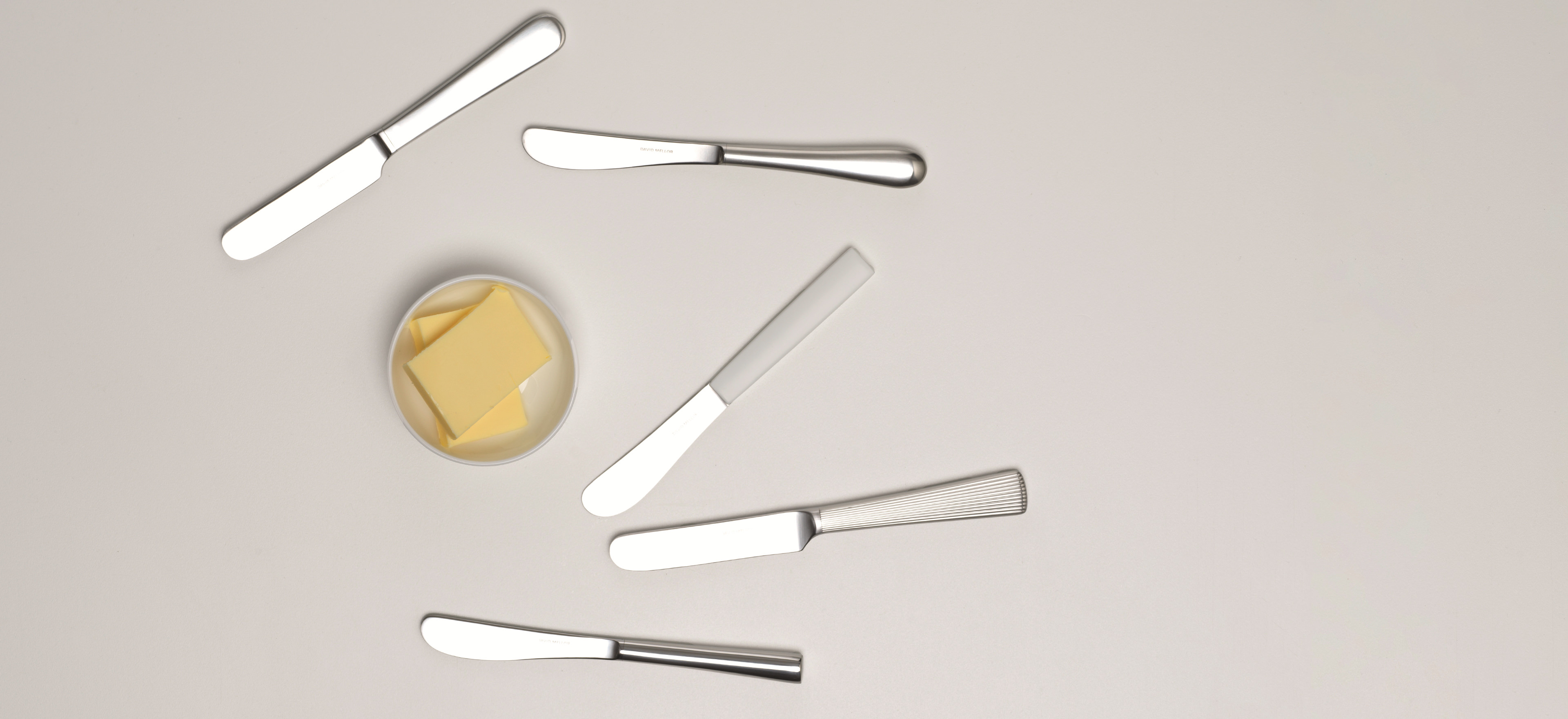 David Mellor butter knives on a light grey background.