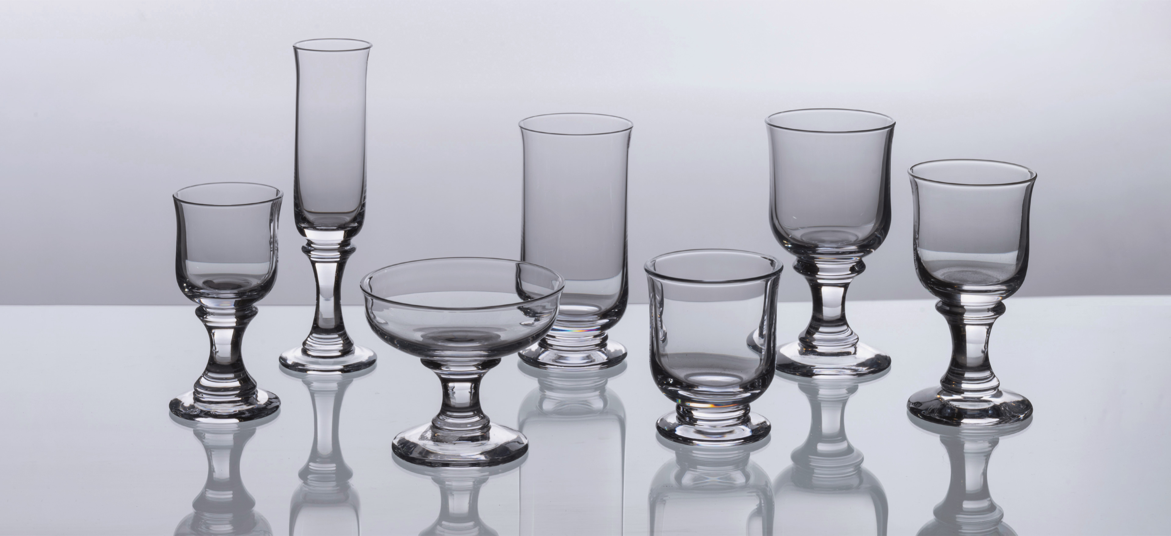 David Mellor Rummer glassware on a grey background.
