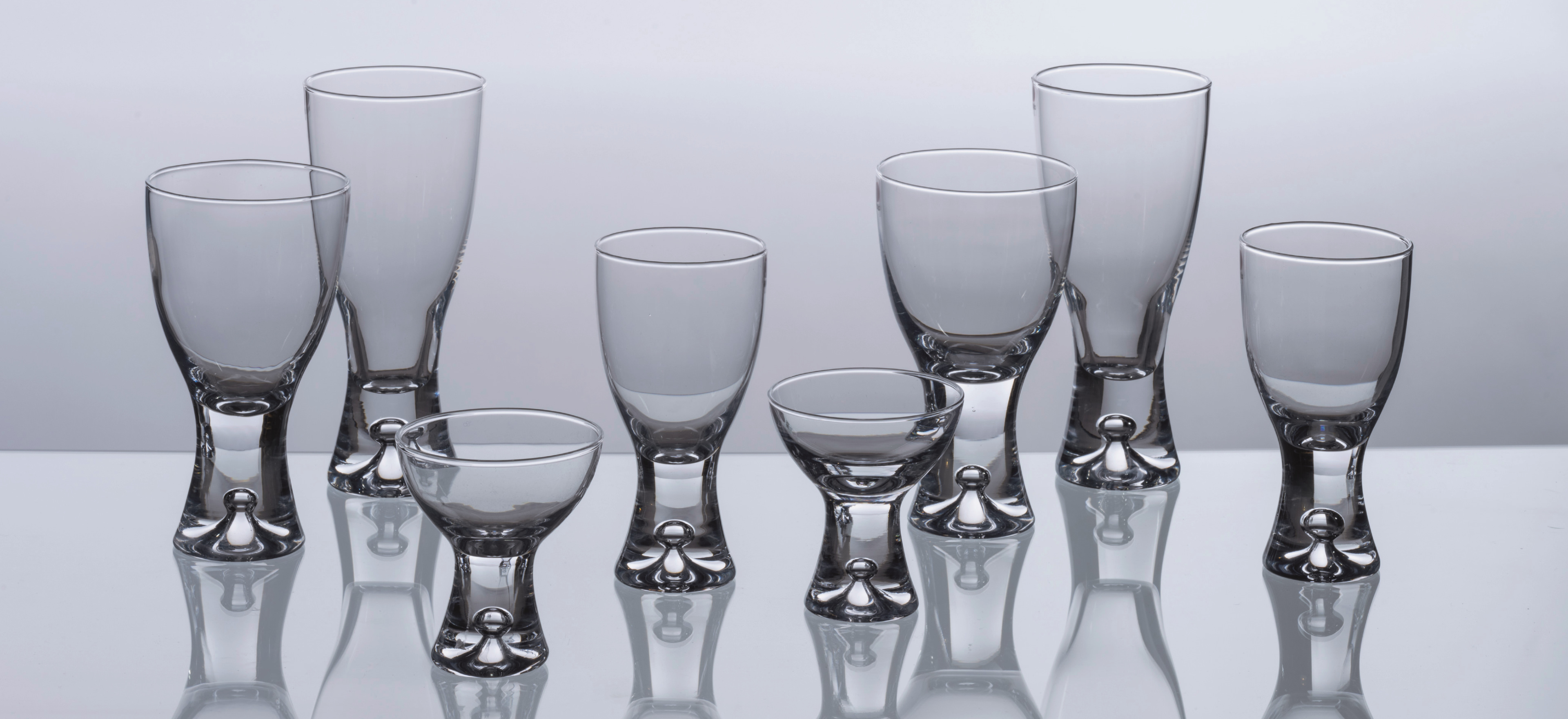 Iittala Tapio glassware on a grey background.