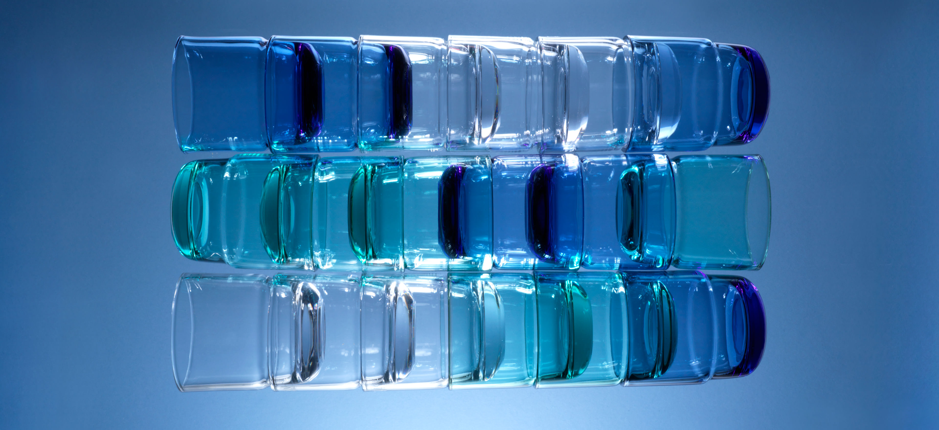 David Mellor stacking tumblers of various colours stacked together on a blue background.