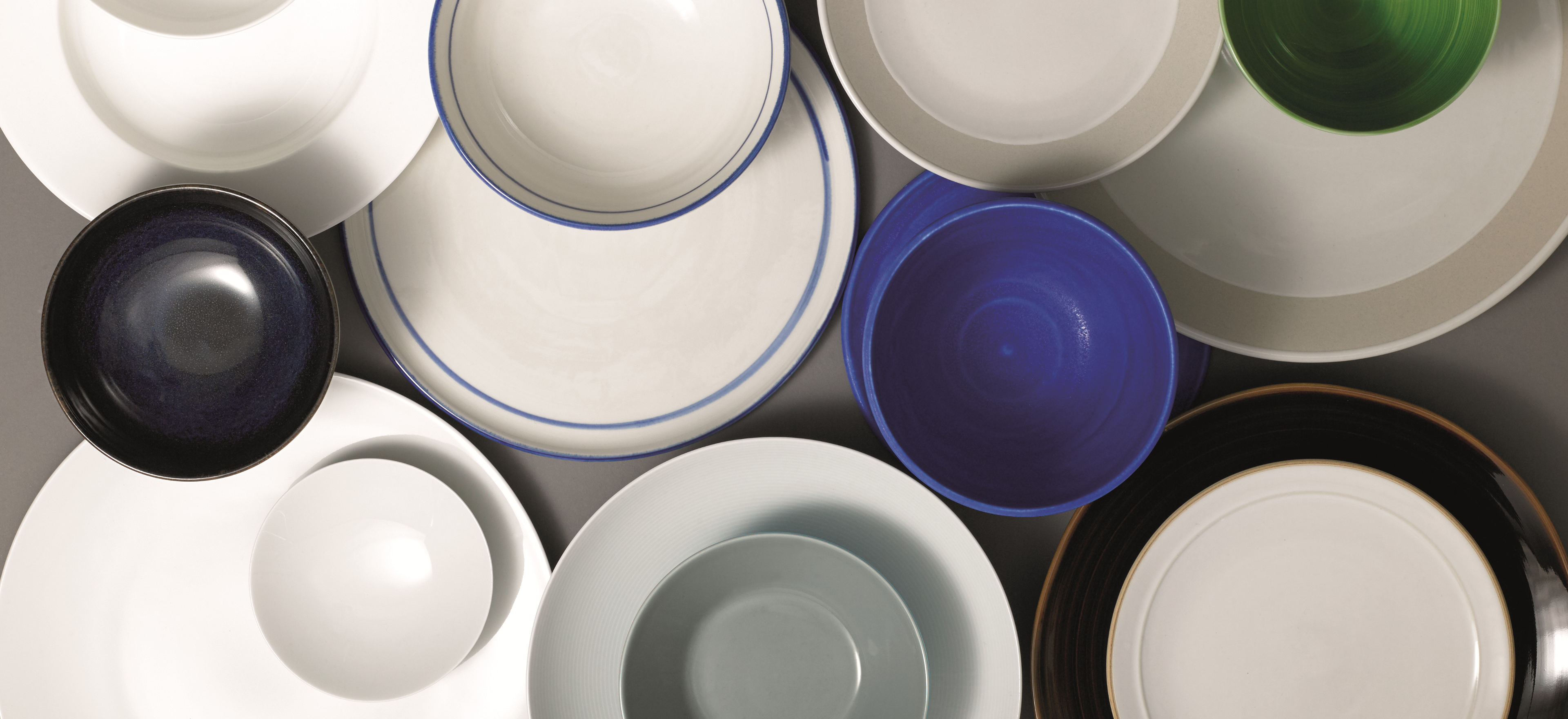 Plates and bowls as viewed from above a table.