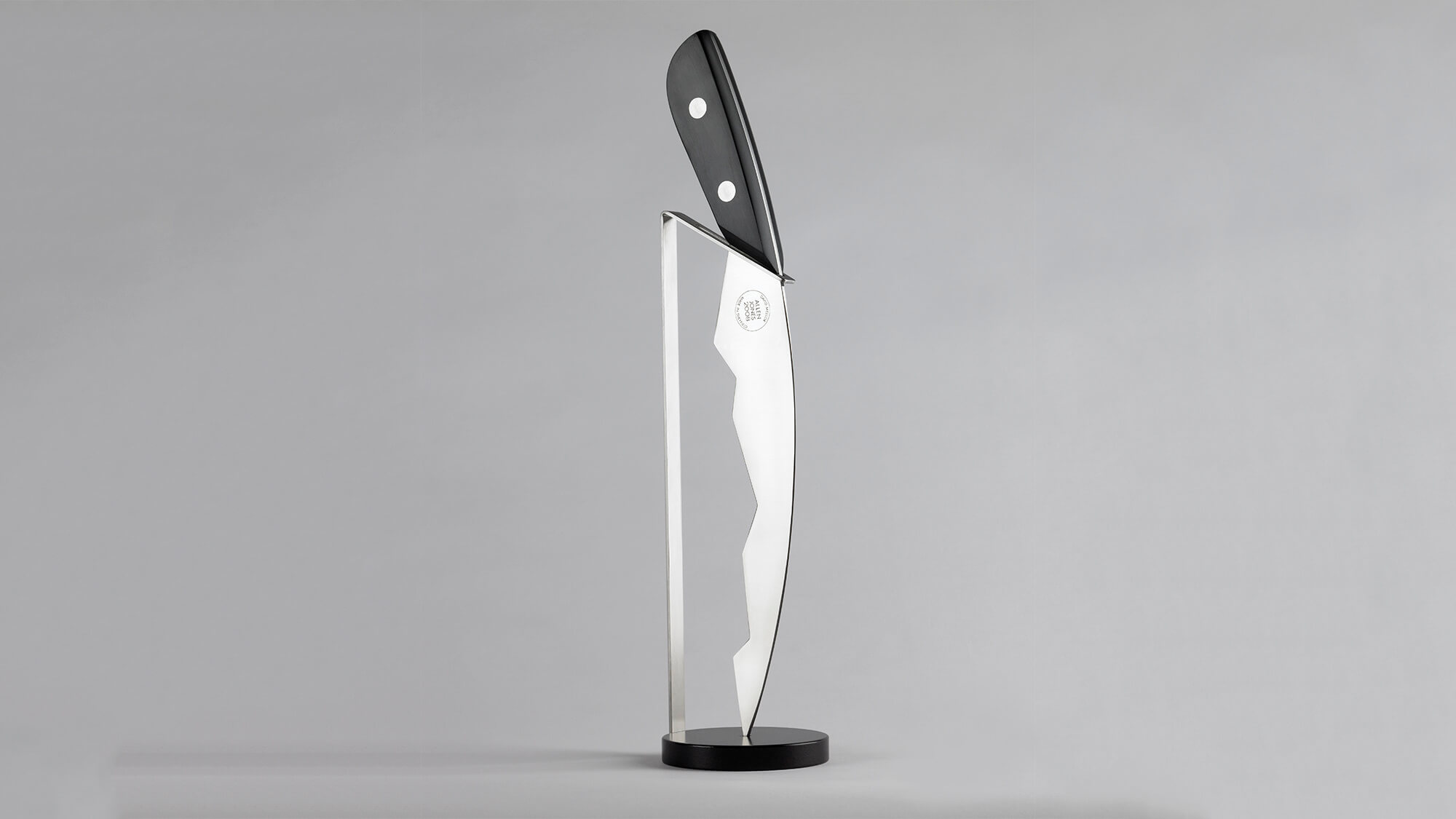 Allen Jones knife sculpture on a grey background.