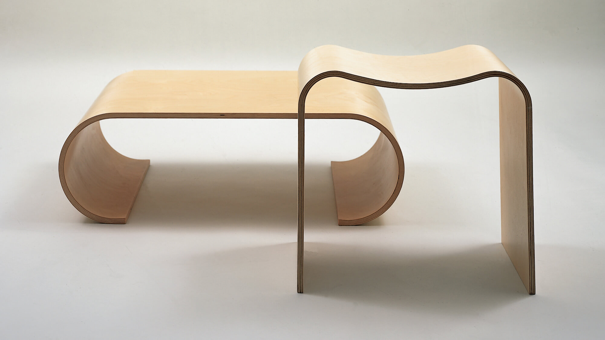 Birch plywood table and stool on a grey background.