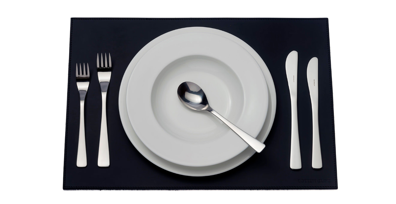 Café cutlery laid out on a table mat.