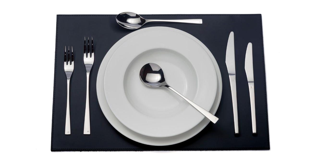 Embassy cutlery laid out on a table mat.