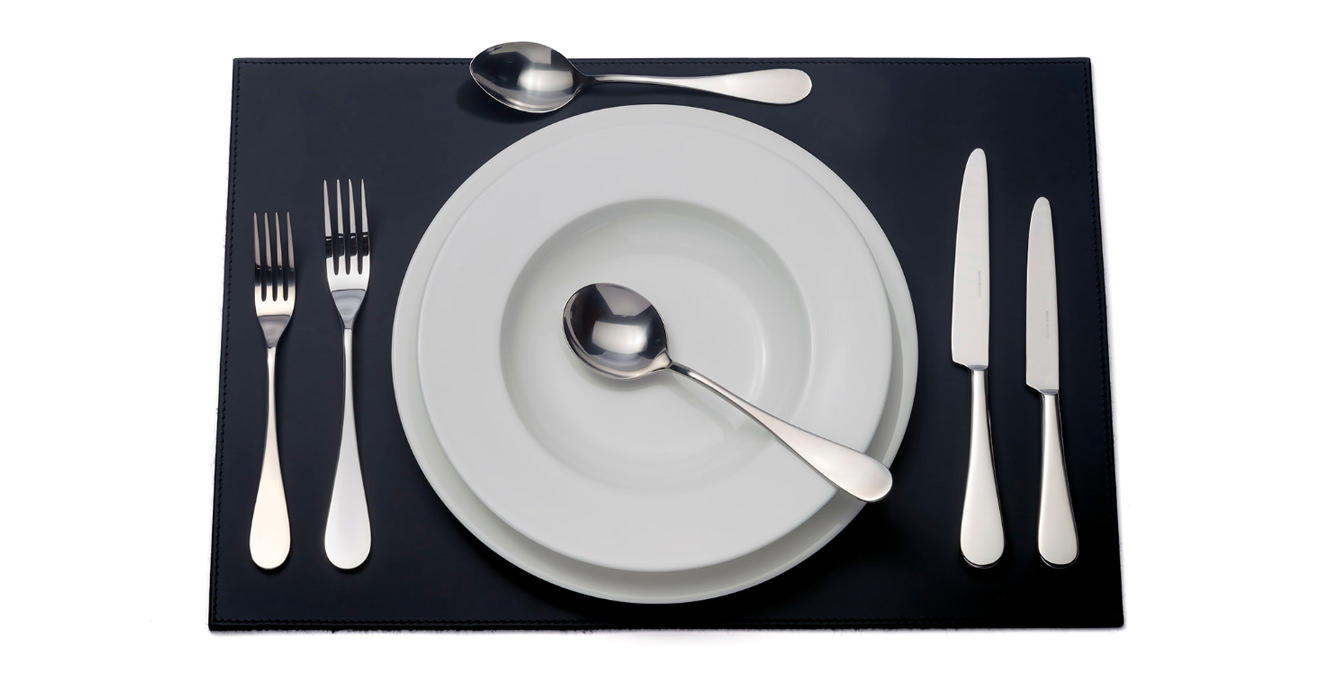 English cutlery laid out on a table mat.