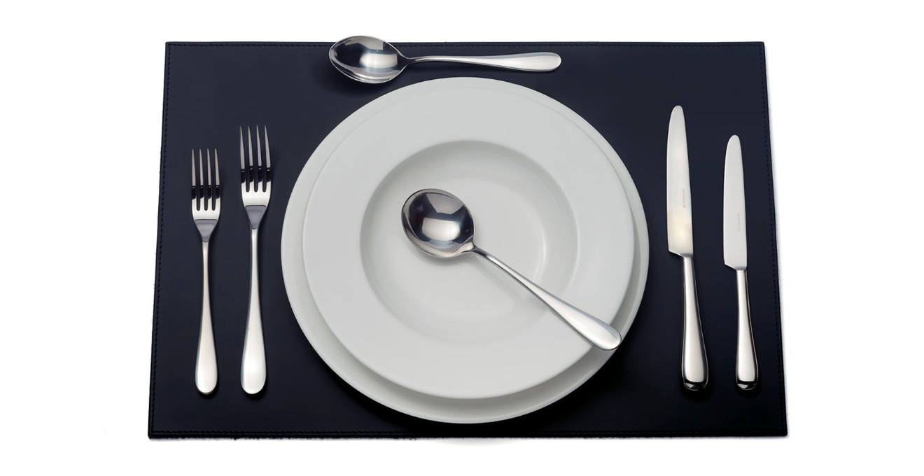 Paris cutlery laid out on a table mat.